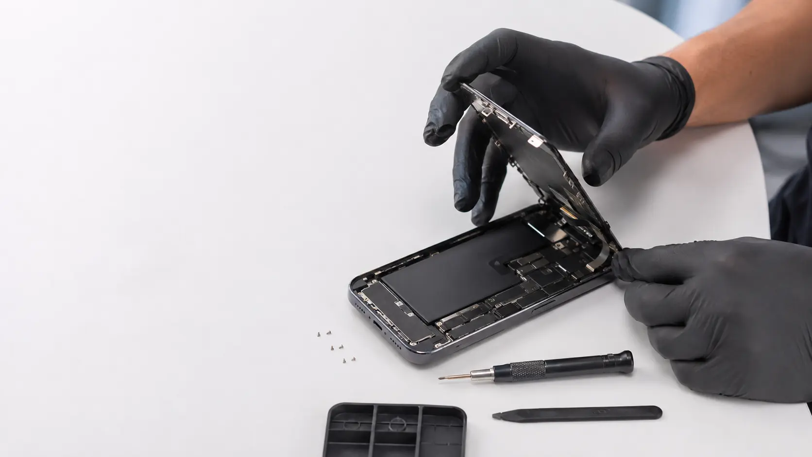 Técnico realizando una reparación de pantalla de iPhone